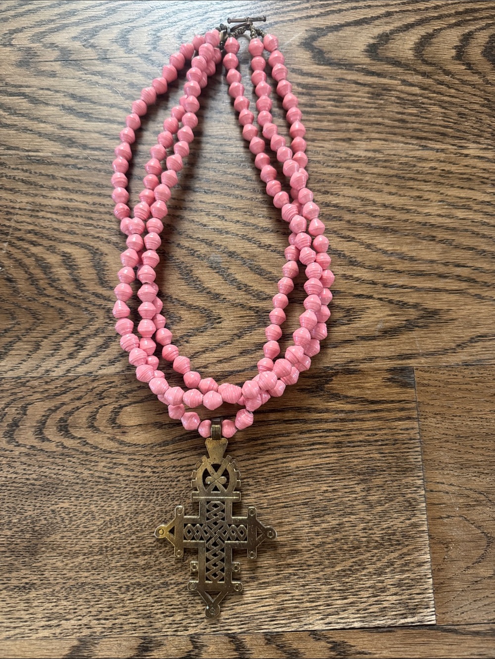 Triple-Strand Pink Beaded Necklace with Decorative Brass Cross